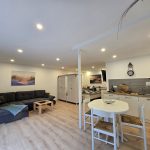 Wohnbereich der Ferienwohnung 19a mit einer Couch, die als zusätzliche Schlafmöglichkeit genutzt werden kann.