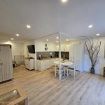 Heller Wohn- und Essbereich der Ferienwohnung 19a mit Küchenzeile, Esstisch und Sitzgelegenheiten