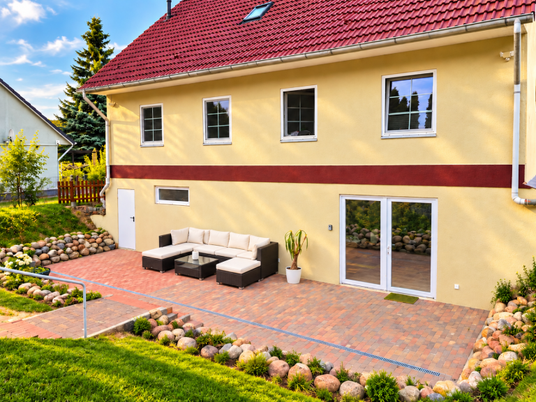 Außenansicht der Ferienwohnung 19a mit Terrasse und Sitzmöbeln